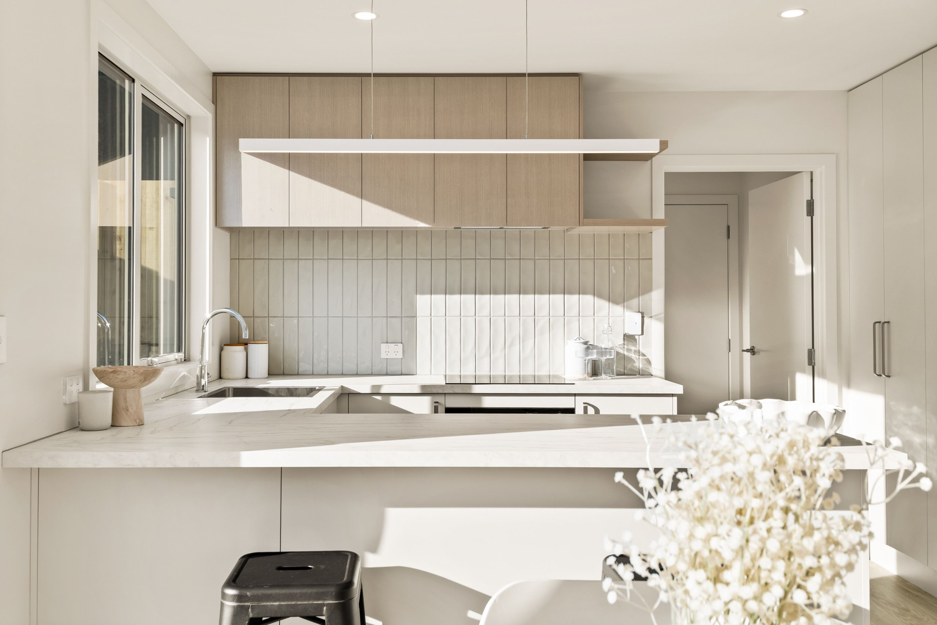 Light-filled Trident Homes kitchen with stone benchtop